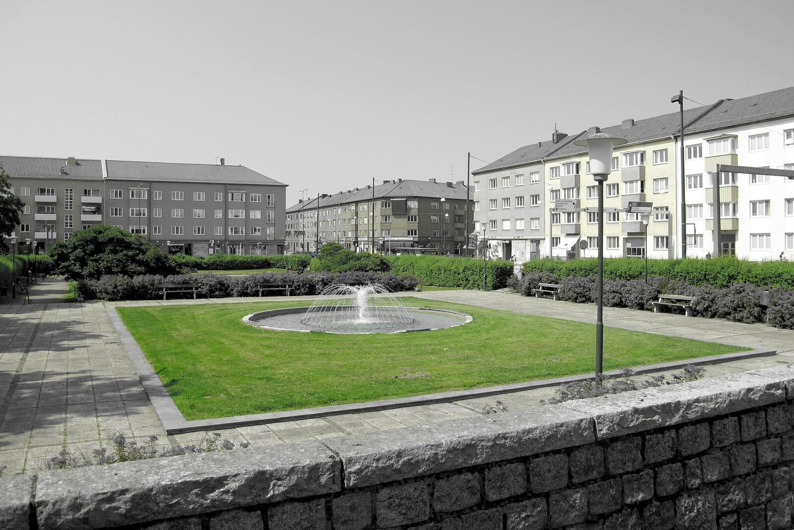 Gårdsplan med fontän framför flerbostadshus